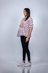 Angled view of Pink Floral Delight Fit & Flare Maternity Top, highlighting the flattering fit and accommodating growing bump with ease.