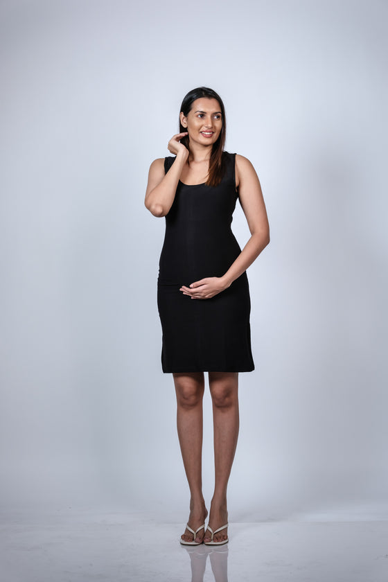 Side-angled view of the Classic Black Maternity Sleeveless Bodycon Dress, showing the flattering body-hugging silhouette.