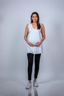  Front view of Classic White Sleeveless Maternity Tunic, showcasing a comfortable and stylish fit for moms-to-be with a flattering V-neckline.