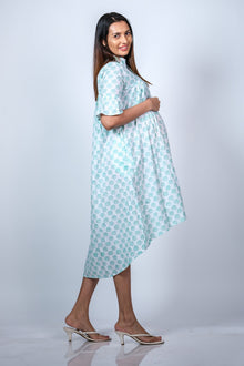  Angled view of Mint Blue Maternity High-Low Dress, showcasing the flowing silhouette and flattering design for growing bumps.