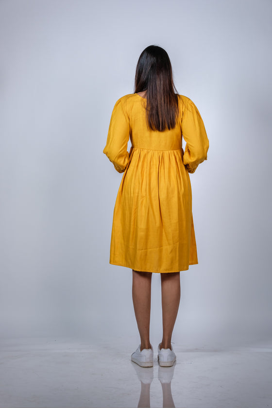 Back view of Mustard Yellow Fit & Flare Maternity Dress, highlighting the flowy and comfortable design, perfect for every trimester.