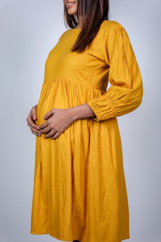 Close-up view of Mustard Yellow Fit & Flare Maternity Dress, showcasing the flattering fit and gathered design to accommodate a growing bump.