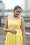 Angled view of Sun-Kissed Ombre Maternity Evening Gown, showcasing the vibrant yellow-to-blue ombre and comfortable fit, perfect for evening strolls.