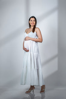  Front view of a white spaghetti-strapped maternity fit & flare dress, showcasing a flowy design perfect for a chic and comfortable pregnancy look.